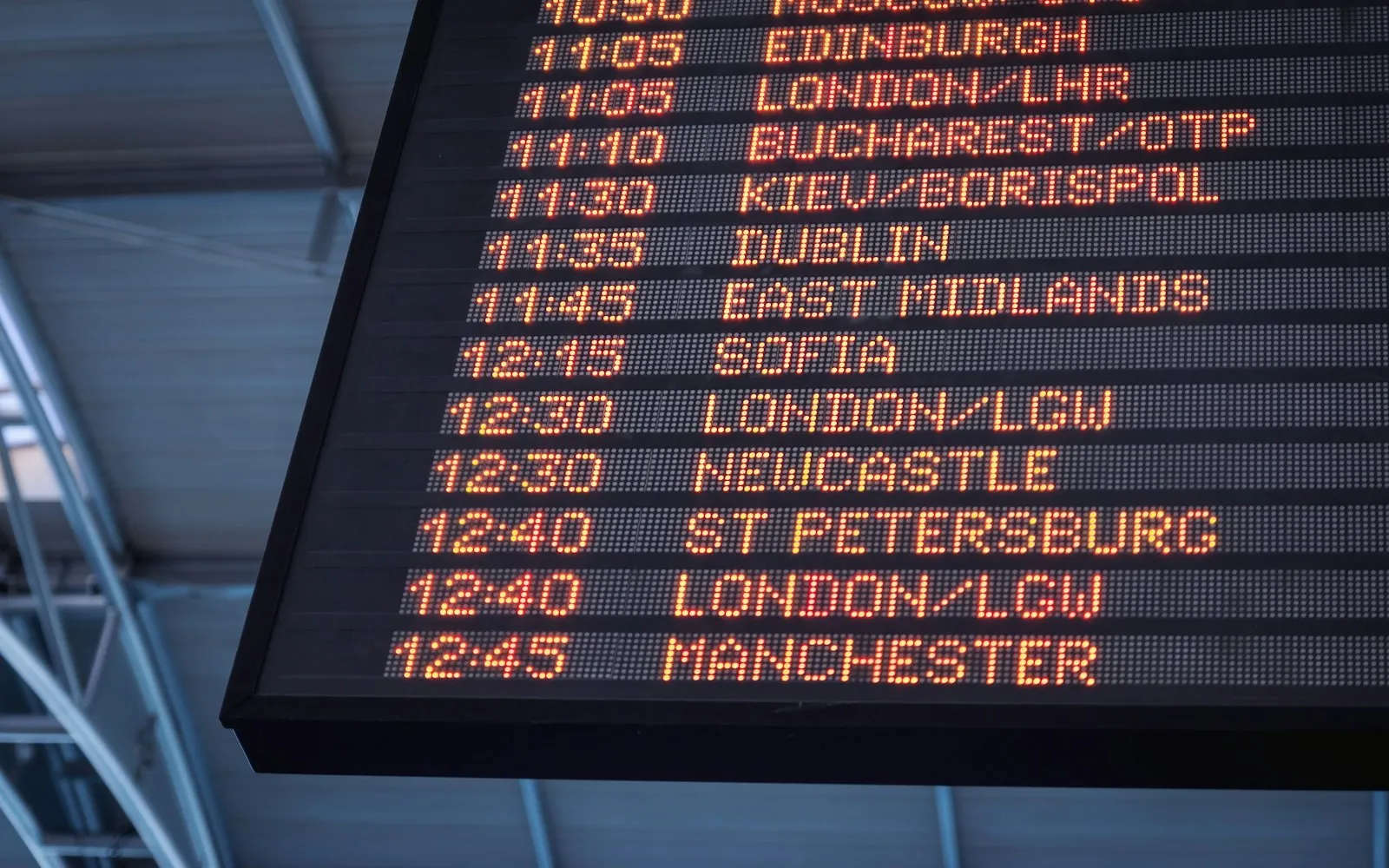 A low-angle shot of a departure board at an airport