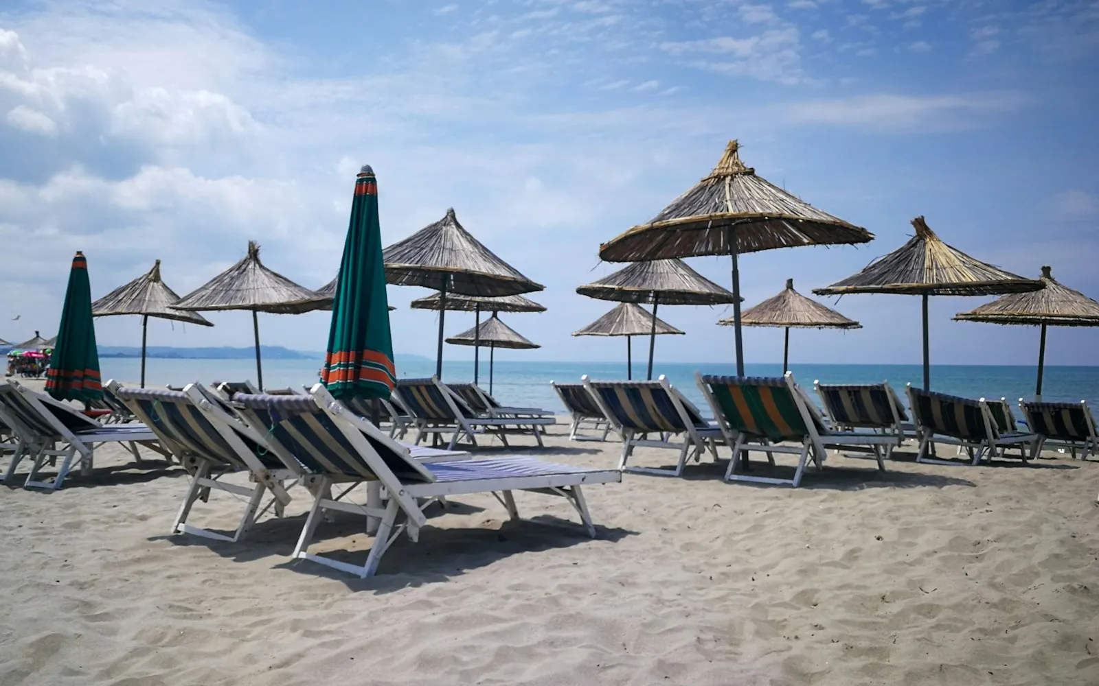 A beach with umbrellas and chairs